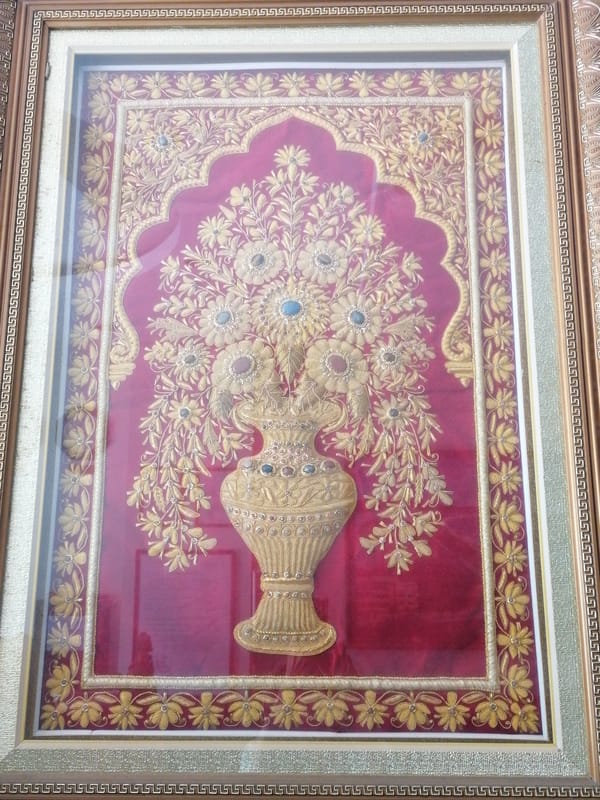 Framed artworks displayed in Nha Trang include floral textile, coastal painting