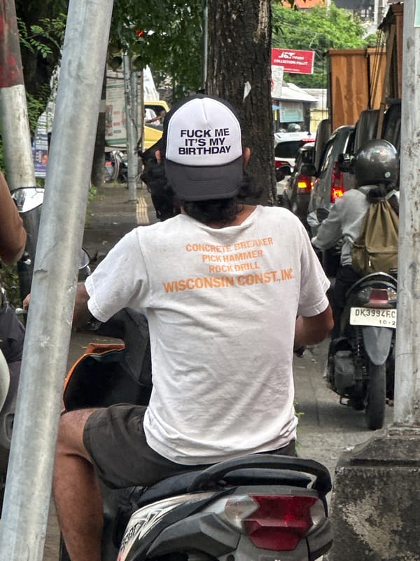 Birthday-hatted construction worker spotted on motorcycle in Denpasar