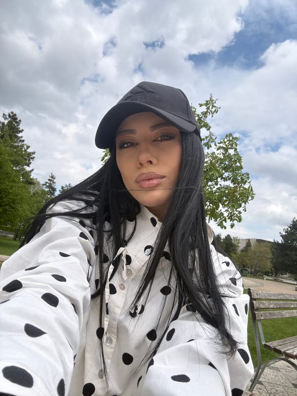 Woman in polka dot shirt photographed outdoors under cloudy skies