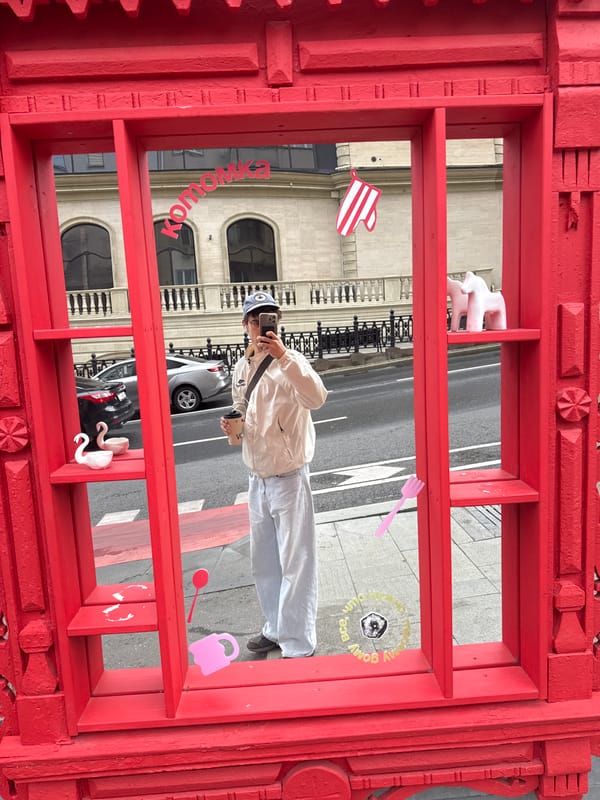 Young person takes selfie behind ornate red frame in Moscow