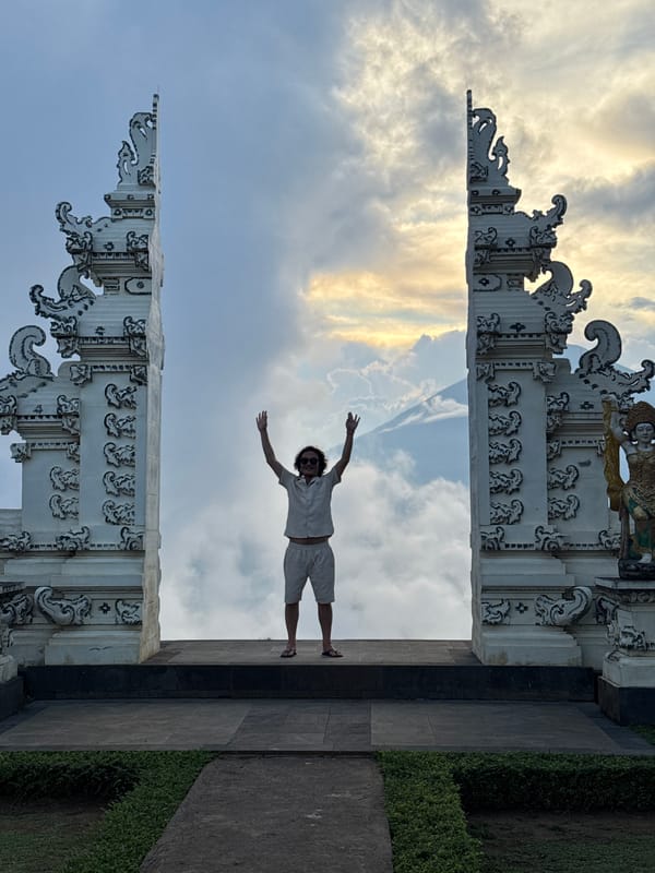 Man poses at traditional Balinese gate in Tista