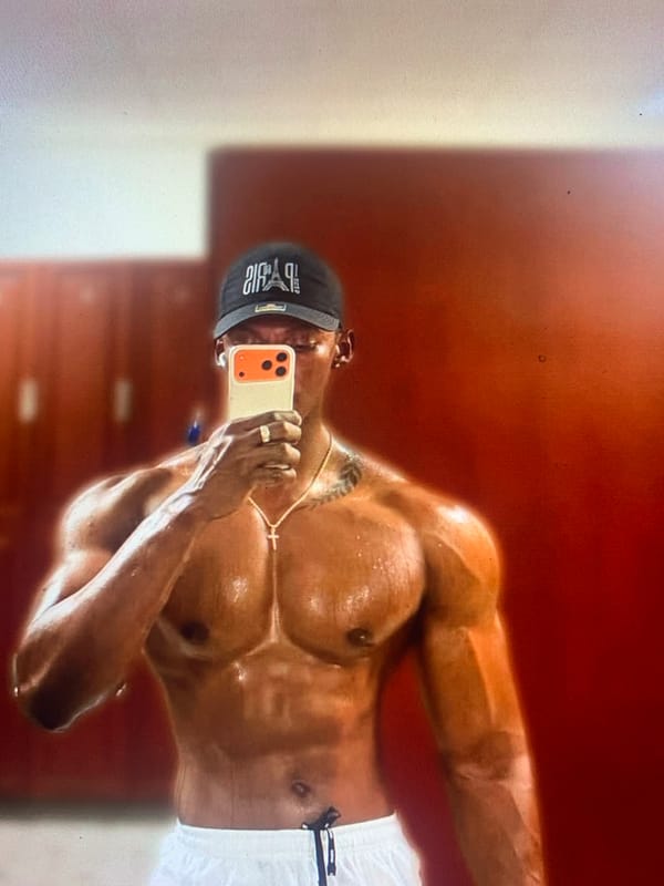 Person takes shirtless mirror selfie with orange phone case