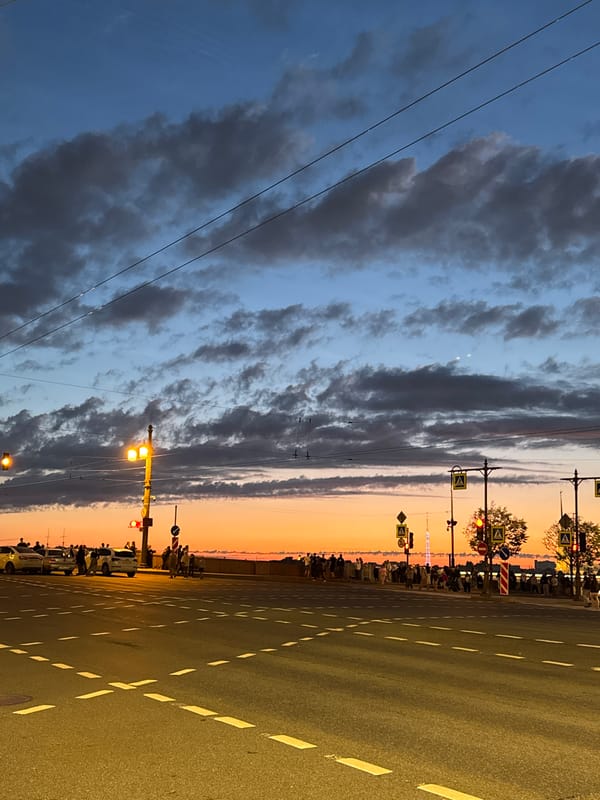 Palace Bridge opens at dusk while crowds gather on the Neva embankment