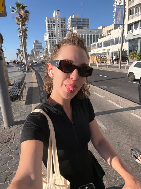 Outdoor selfie in Tel Aviv, sunglasses and earbuds on.