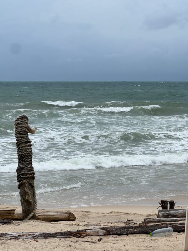 Red flag up, rough seas, empty chairs on a stormy beach.