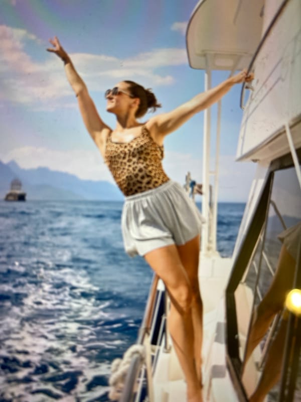 Arms out over the railing on a mountain-backed boat trip