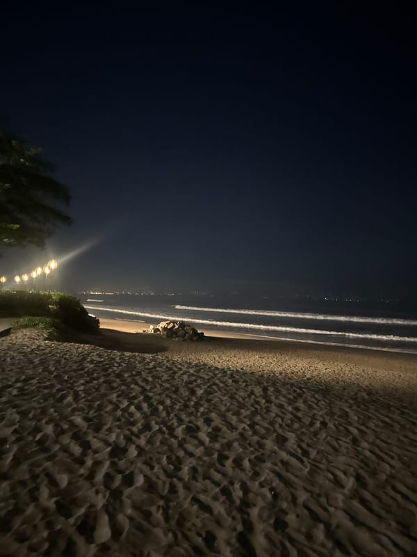 North Kuta beachfront lit up at night with string lights and surf