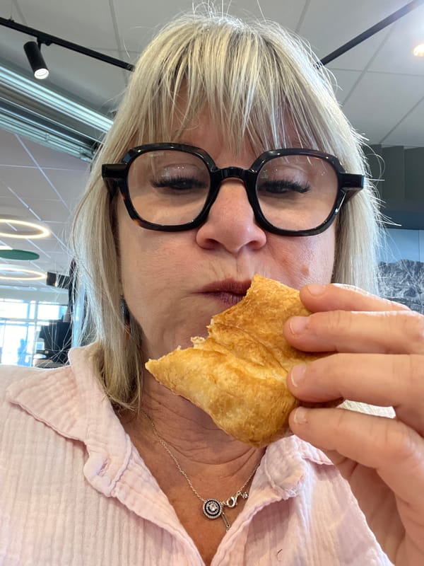 Woman enjoys breakfast croissant at Rousset cafe Friday morning