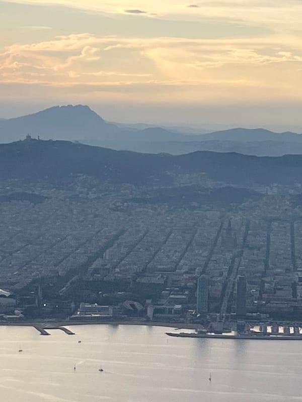 Elevated view captures Barcelona cityscape at dusk from unknown location