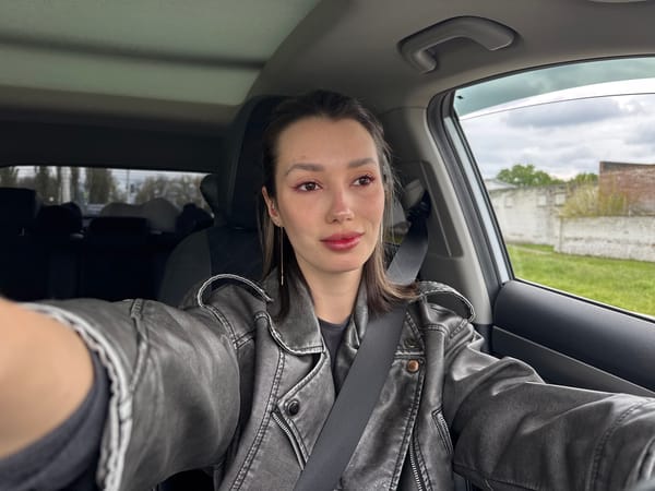 Woman in gray jacket observed in car during urban drive