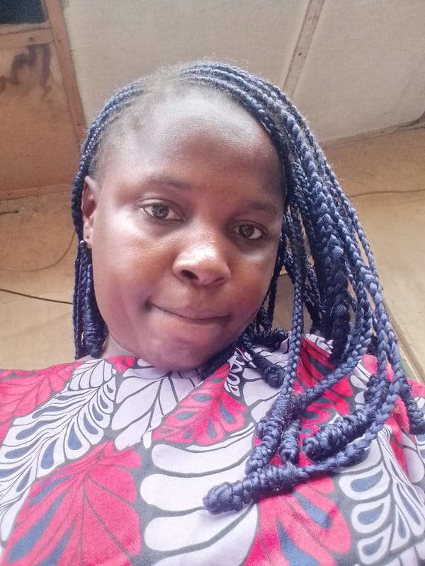 Woman takes selfie wearing vibrant floral top with blue-highlighted braids
