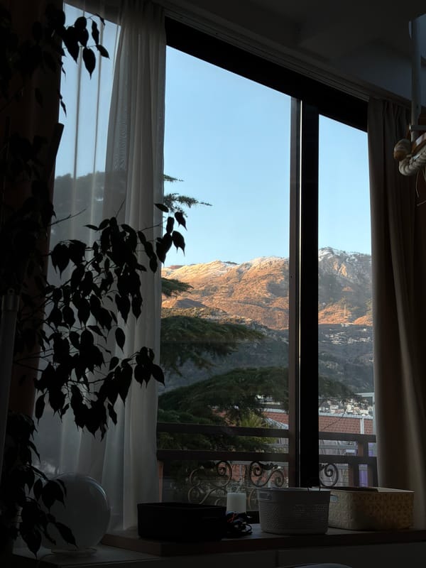 Indoor window view captures Montenegro mountain landscape in Budva