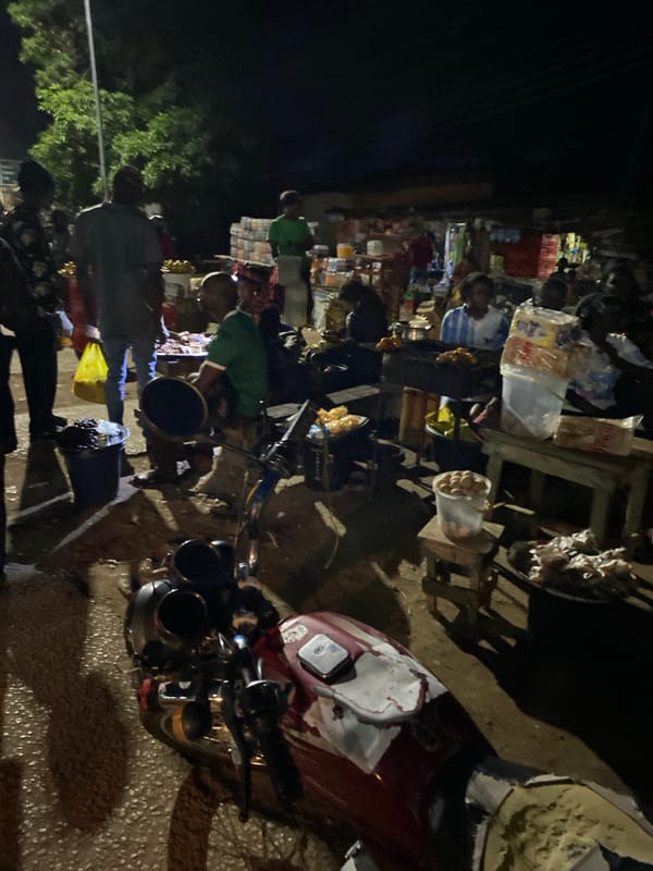 Nighttime street market bustles with vendors in Bukuru, Nigeria