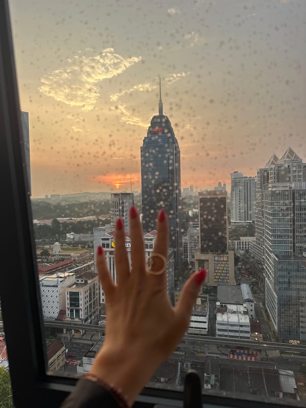 Rainy window view captures Kuala Lumpur cityscape from high-rise
