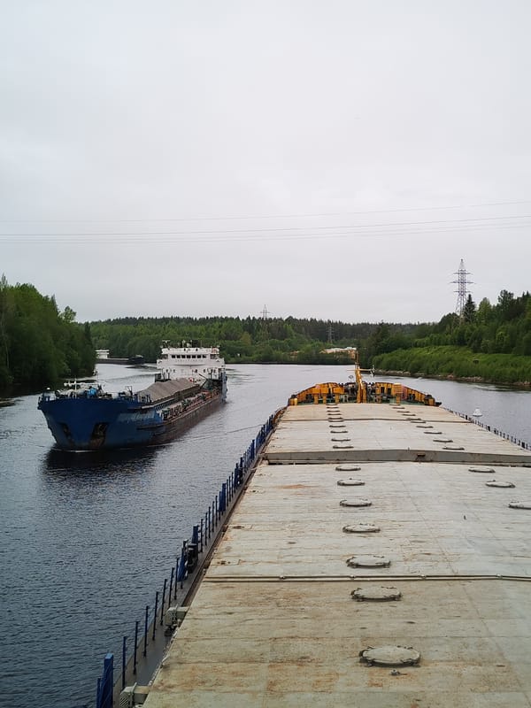 Cargo barges navigate Russian waterway carrying gravel and sand