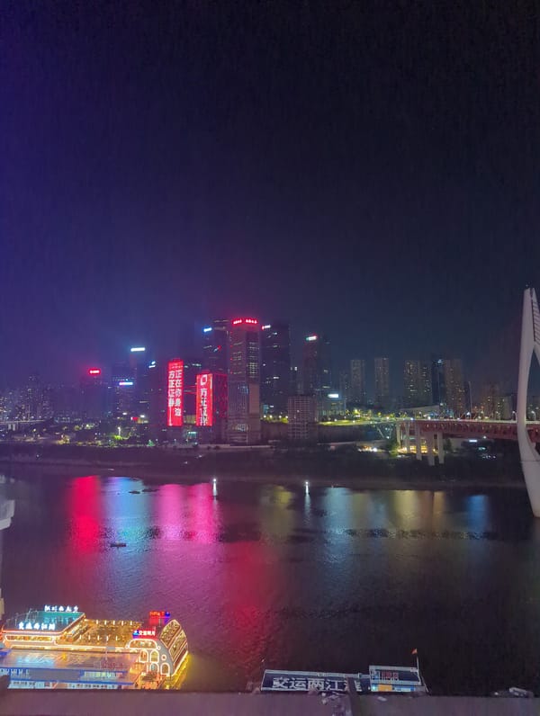 Chongqing's Yuzhong waterfront glows at night with docked river boat