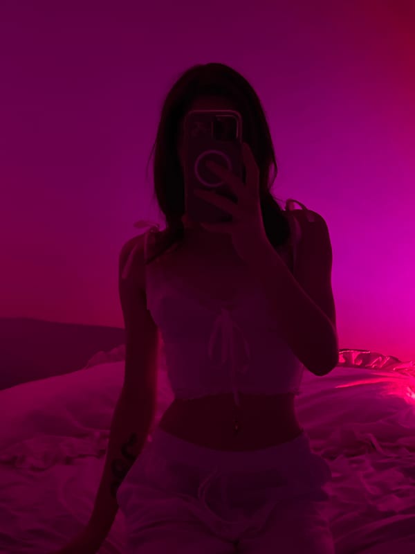 Bedroom selfie session under pink and purple ambient lighting