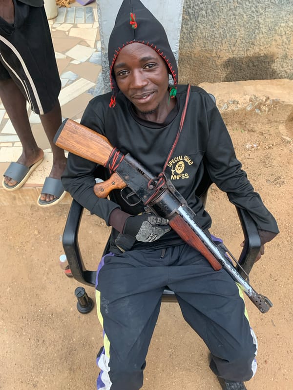 Armed squad member and civilian observed at Nigerian stadium