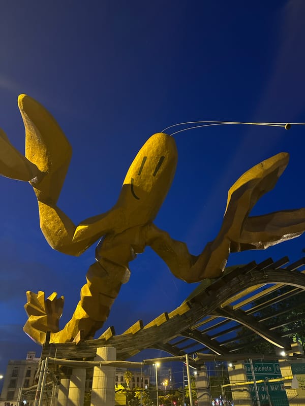 Golden lobster sculpture illuminated at night in Barcelona plaza