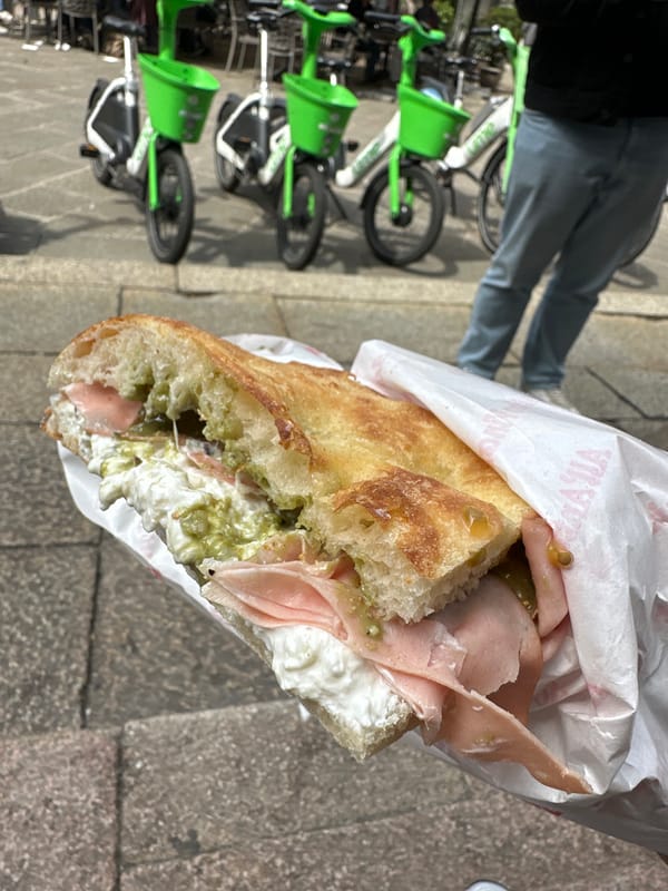Person enjoys sandwich lunch on Milan streets