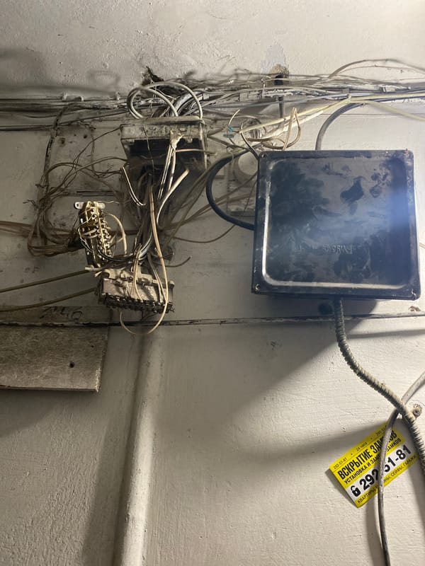 Cluttered wires and windowsill plants at an unidentified spot