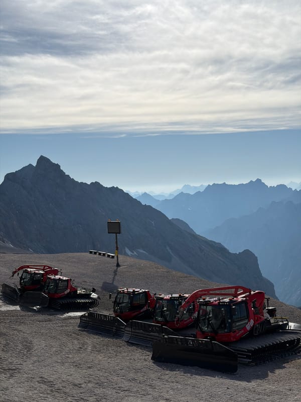 Red snow groomers parked on a mountain slope in Garmisch-Partenkirchen