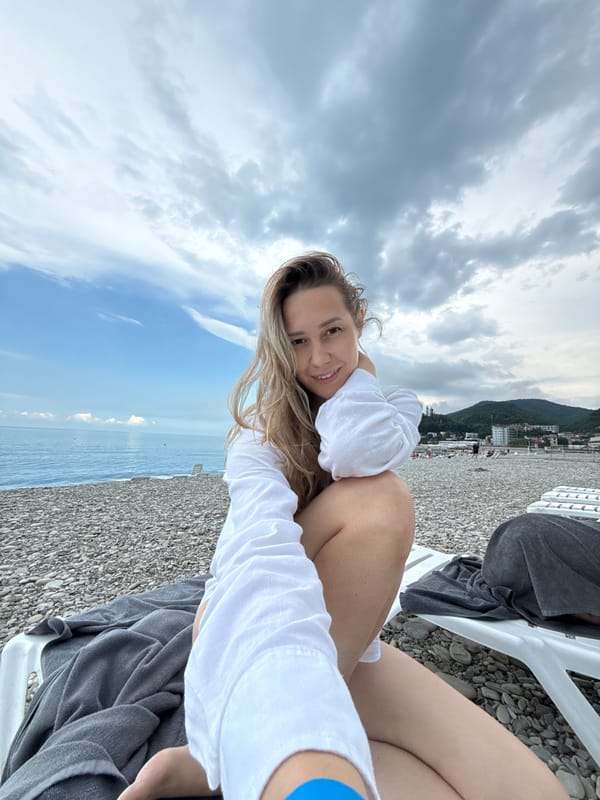 Woman photographs beach visit in Nebug, Russia