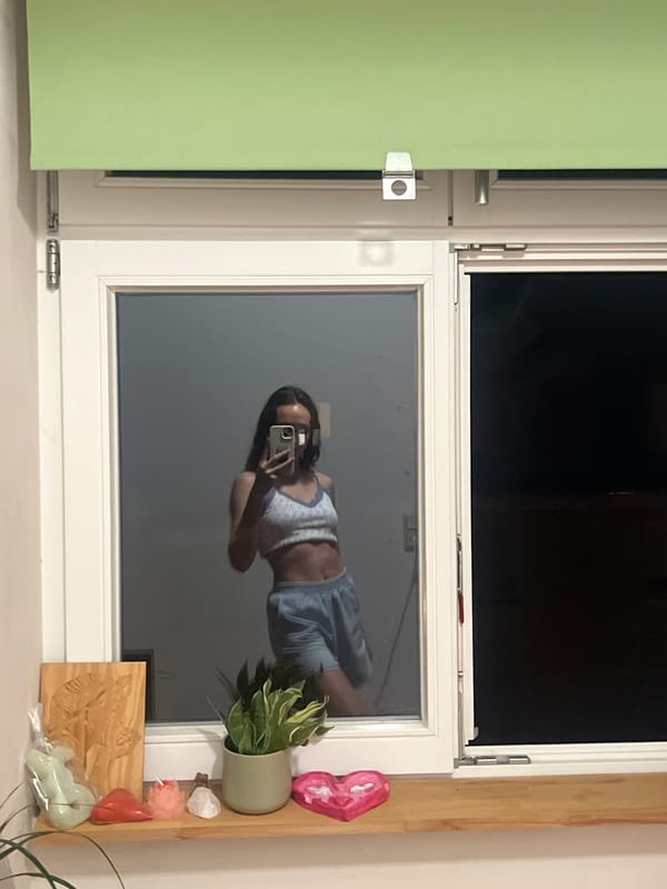 Person photographed in window reflections while taking selfies, Saarbrücken