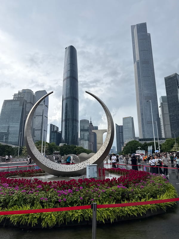 Crowds fill Tianhe's wet plazas near the stadium and Canton Tower