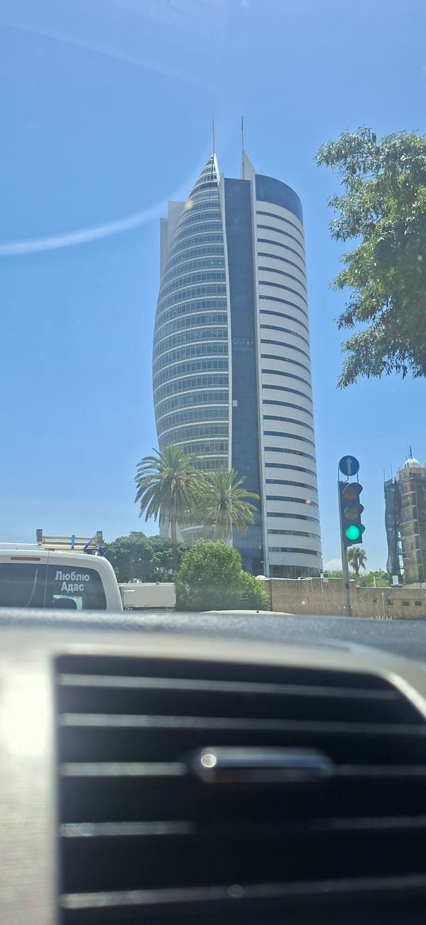 Curved glass office tower with twin spires dominates the skyline