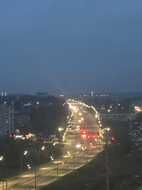 Aerial nighttime view captures illuminated curved city road