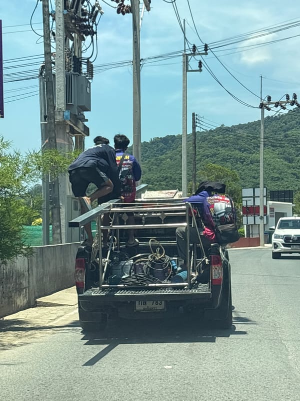 Pickup truck carries three passengers through Choeng Thale vegetation