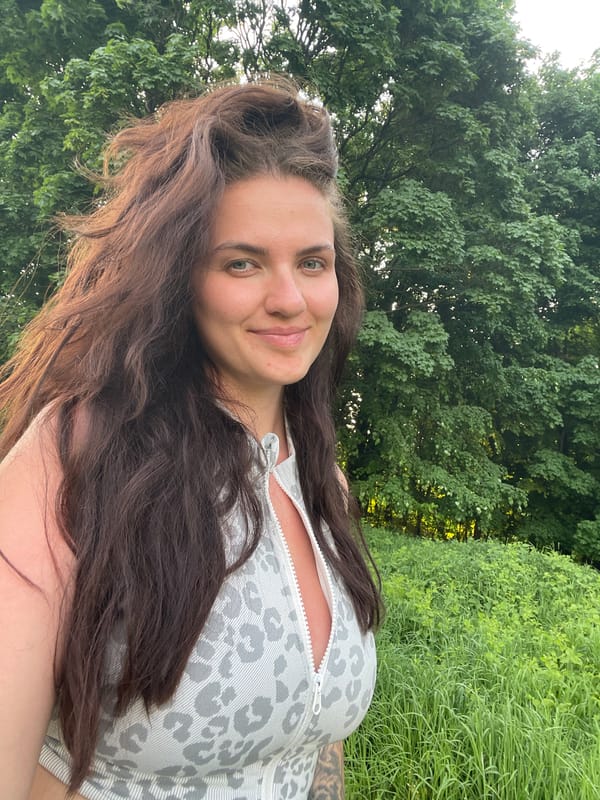 Woman documents outdoor selfie session in Russian field setting