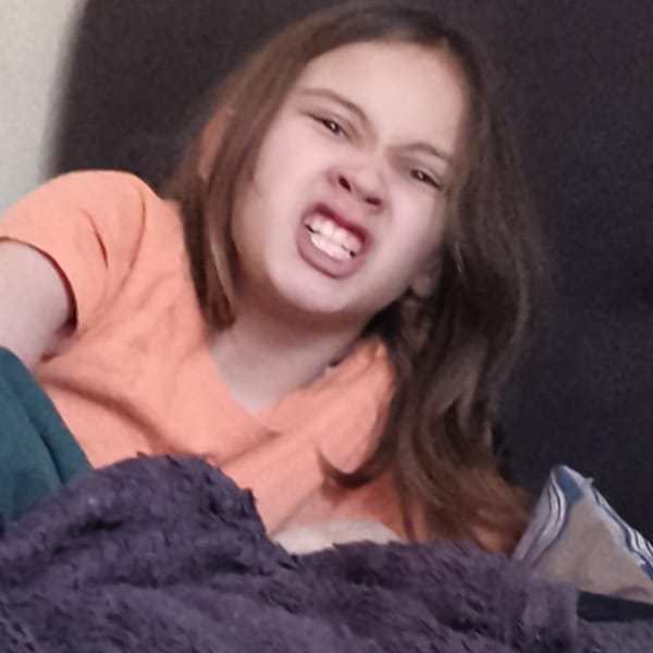 Woman takes selfie near baby on colorful play mat