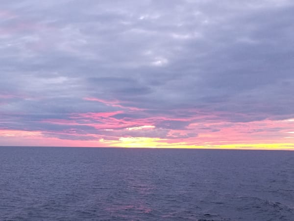 Deep blue water at dusk, horizon quiet and still.