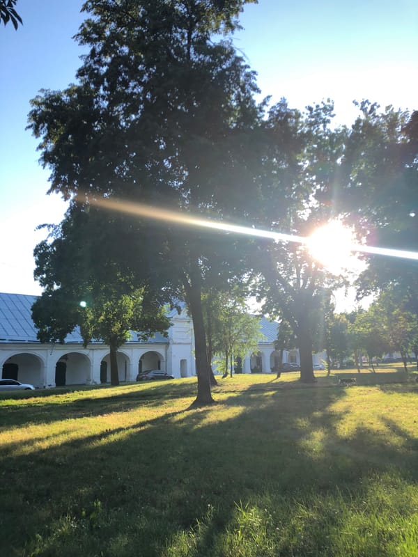 Sunlit white colonial building with arched walkways and courtyards