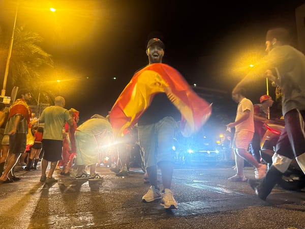 Spanish flags raised during a Barcelona street celebration at night