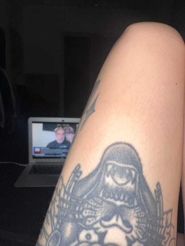 Tattooed person uses MacBook for social media in Buenos Aires