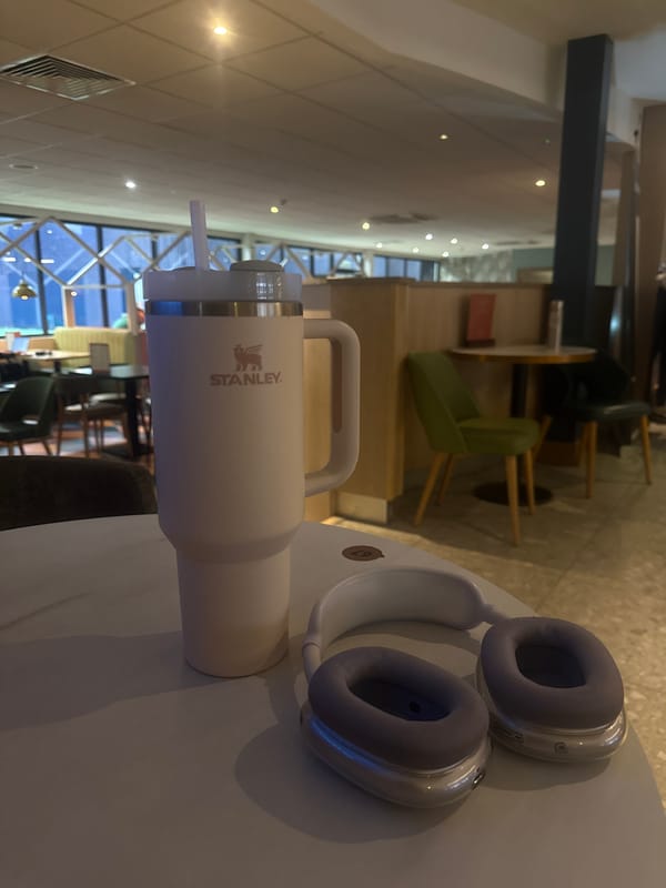 Travel mug and headphones spotted on London coffee shop table