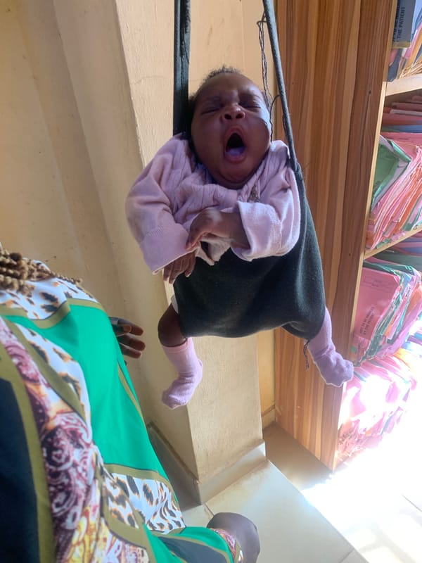 Baby weighed in fabric sling at Jos clinic