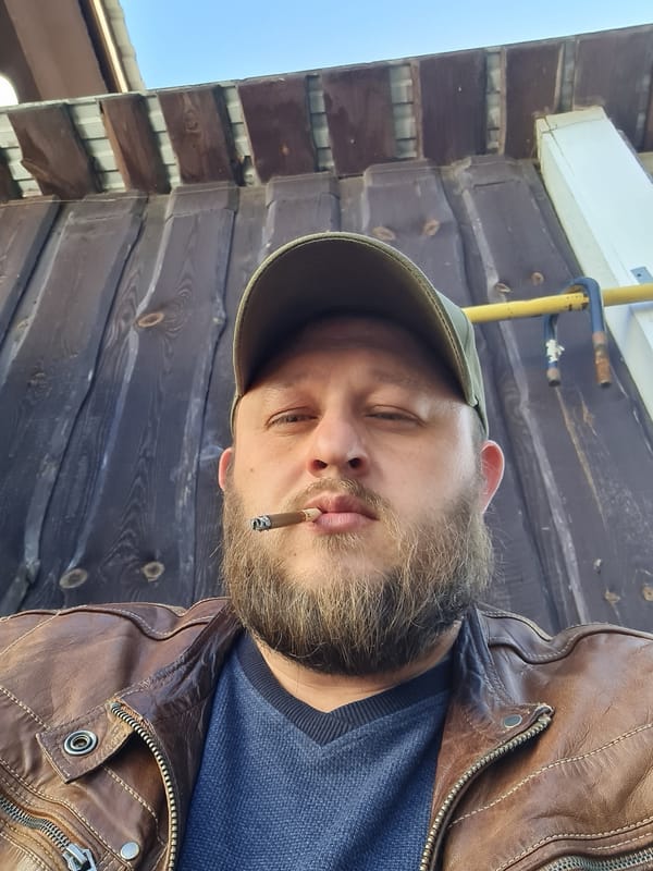 Man smoking cigarette outside wooden building in Russia