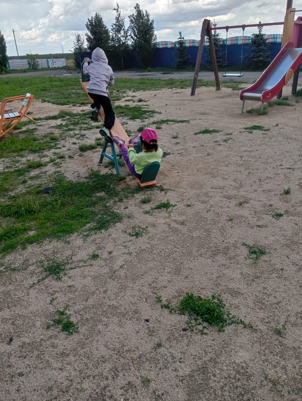 Children play in rural playground amid everyday community scenes