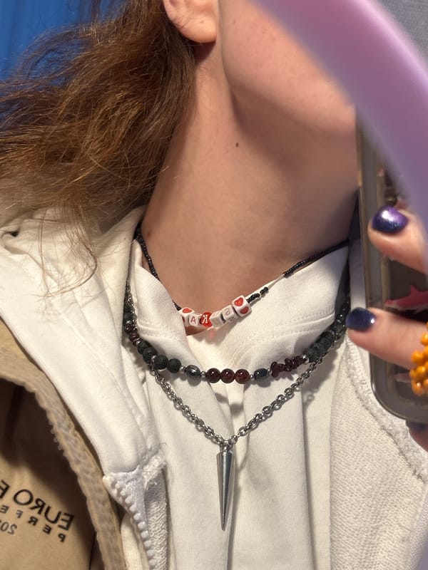 Person photographed wearing white hoodie, multiple necklaces in Krasnoyarsk