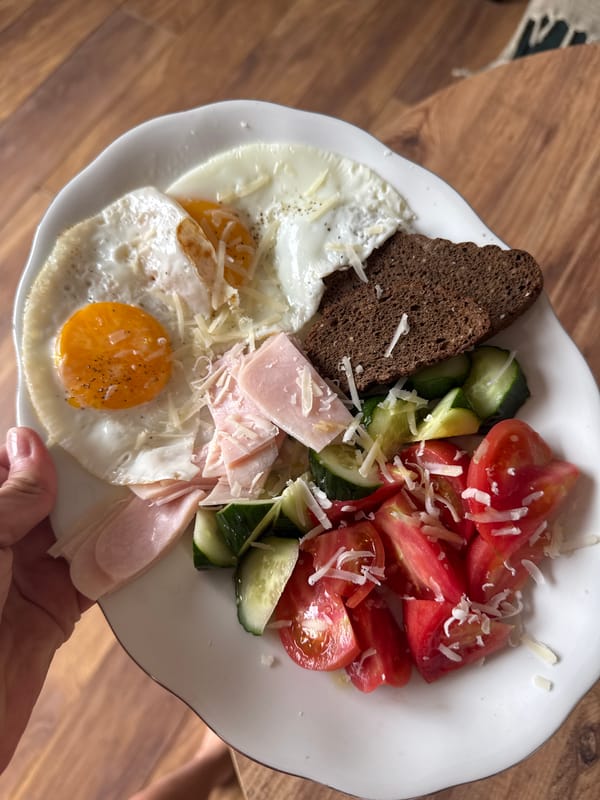 Breakfast plate with eggs, ham, bread, salad documented