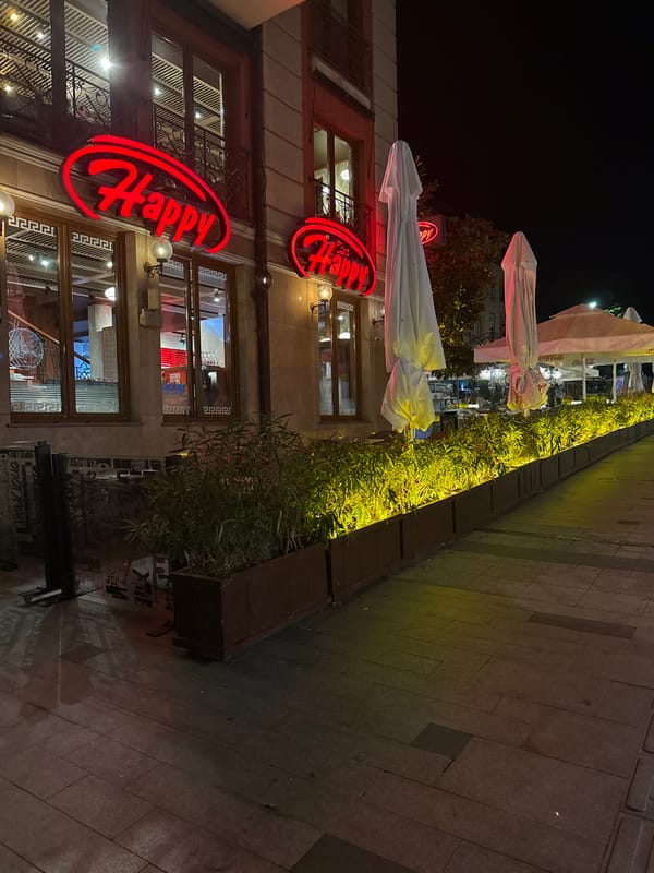 Nighttime city block with neon signs and quiet streets