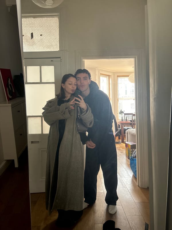Couple takes playful mirror selfie in London hallway