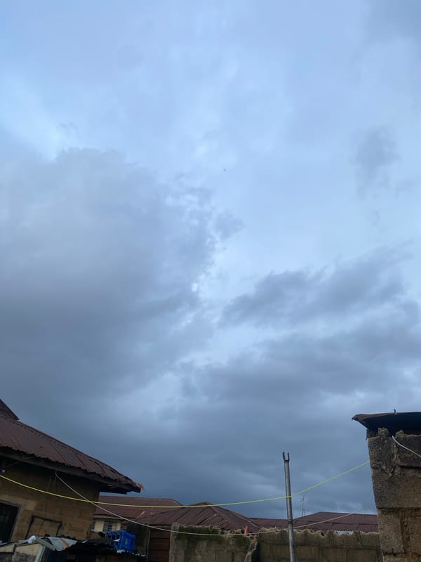 Street life and overcast skies across a Jos neighborhood