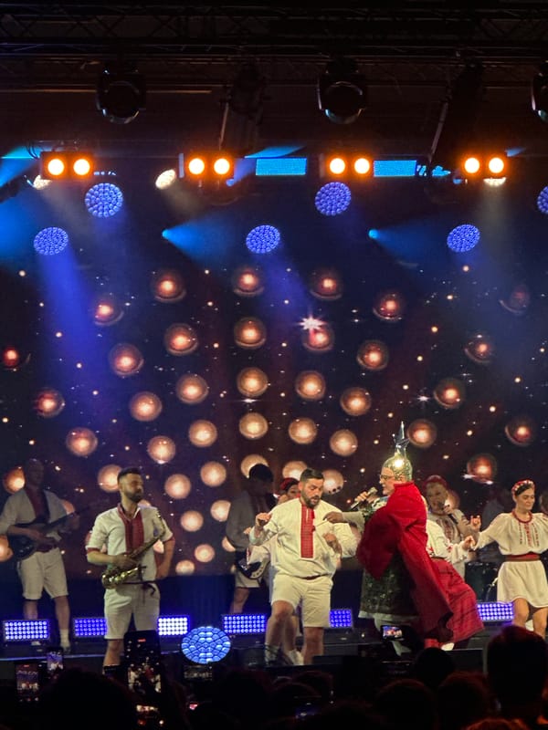 Music group performs at packed concert venue with elaborate lighting