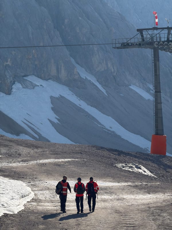 Early morning on the Zugspitze summit, hikers and snow groomers