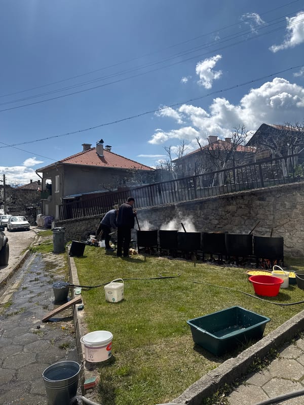 Two men tend fire with containers in Dobarsko